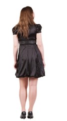 back view of standing beautiful   woman. Young blonde girl in black dress and  kitten heels. Rear view. Isolated over white background. 