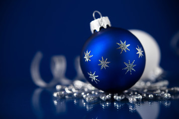 Silver, white and blue christmas ornaments on dark blue background. Merry christmas card. Happy holidays.