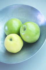 Three green apples on dish