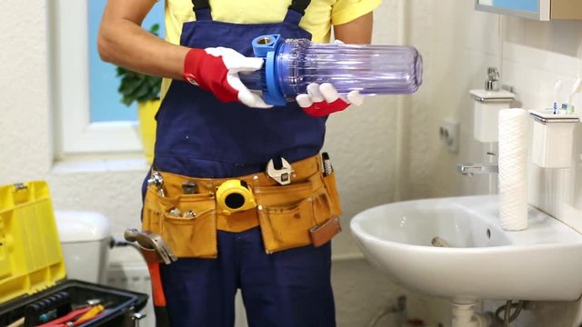 plumber installing new water filter in bathroom