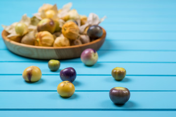 Ripe physalis in a wooden bowl.