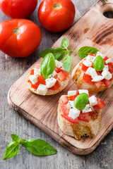 Caprese salad bruschettas on wooden table

