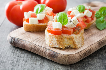 Caprese salad bruschettas on wooden table

