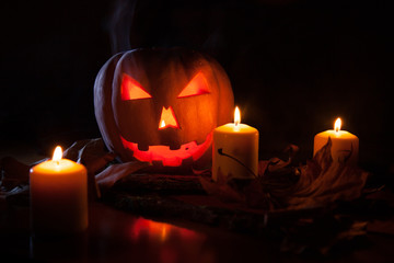 Calabaza de Halloween adornada con velas sobre un fondo oscuro