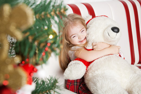 Homemade Christmas, girl hugging a teddy bear.