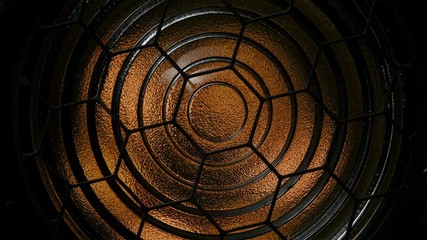 Spotlight with Fresnel lens slowly turn off in front of black background.
