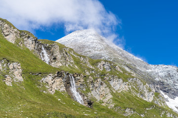 Alpenidylle in den Hochalpen von Österreich mit Wasserfall und Berggipfel
