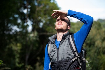 Male hiker shielding his eyes
