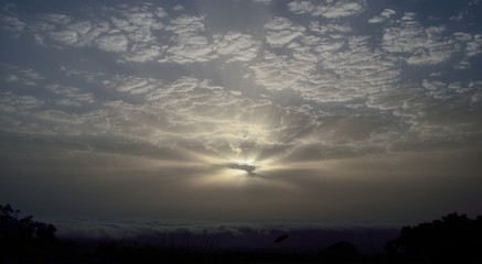Amazing dawn with sunrays through the clouds