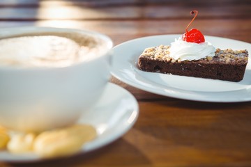 Pastry with whipped cream and cherry topping on table