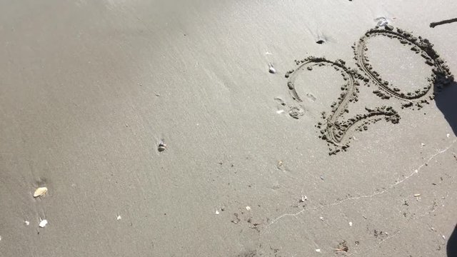 2017 written in sand on tropical beach, happy new year holiday 