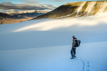 Adventurer at the edge of a glacier overlooking Arctic landscape