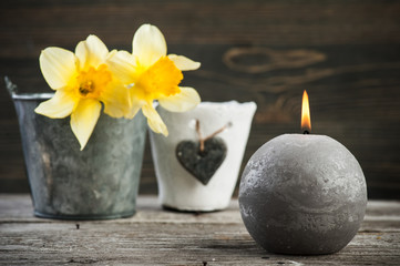 Lit candle and yellow flowers