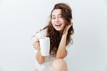 Charming lovely young woman with long hair holding cup