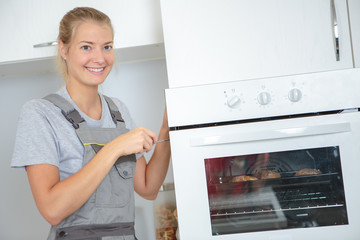 Fototapeta na wymiar Portrait of lady repairing oven
