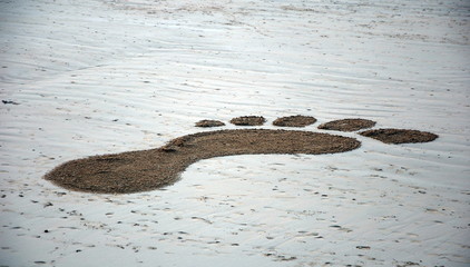 Painted footprint in the sand. Saint-Malo, Brittany, France