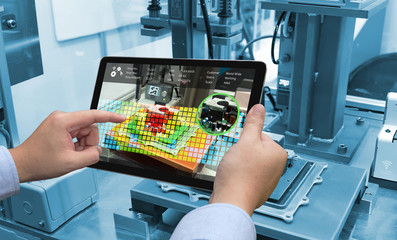 Industry 4.0 concept .Man hand holding tablet with Augmented reality screen software and blue tone...