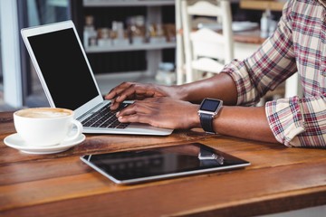 Mid-section of a man using laptop