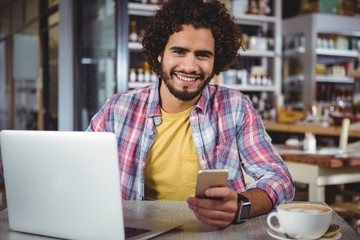 Portrait of happy man holding mobile phone