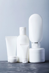 White cosmetic bottles on a grey table