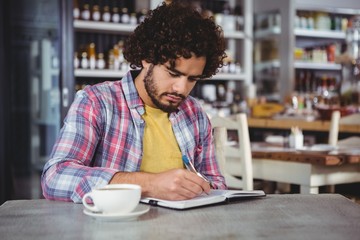 Man writing on a diary 