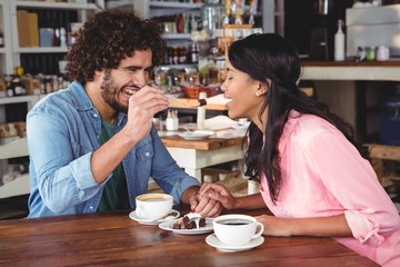 Man feeding dessert to woman