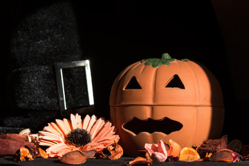 halloween pumpkin, front view, with dried flowers potpourri and black background