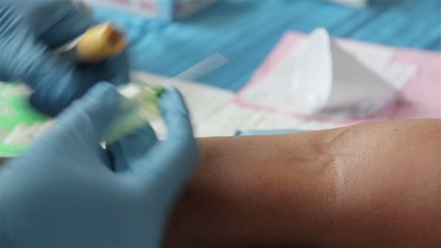Donor gives blood to a doctor for health check.