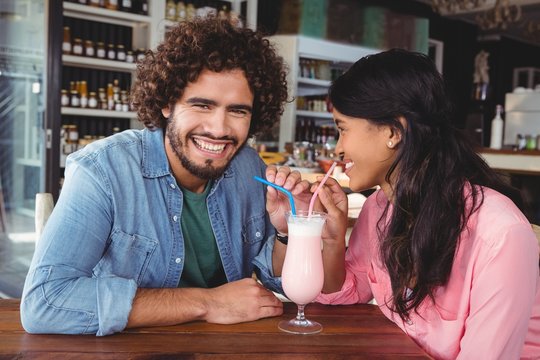 Happy couple drinking milkshake