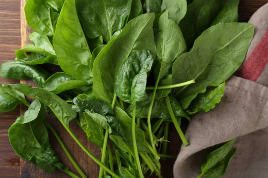 Fresh spinach leaves on rustic wood