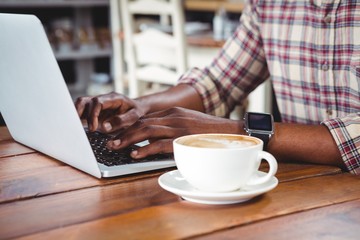 Mid-section of a man using laptop