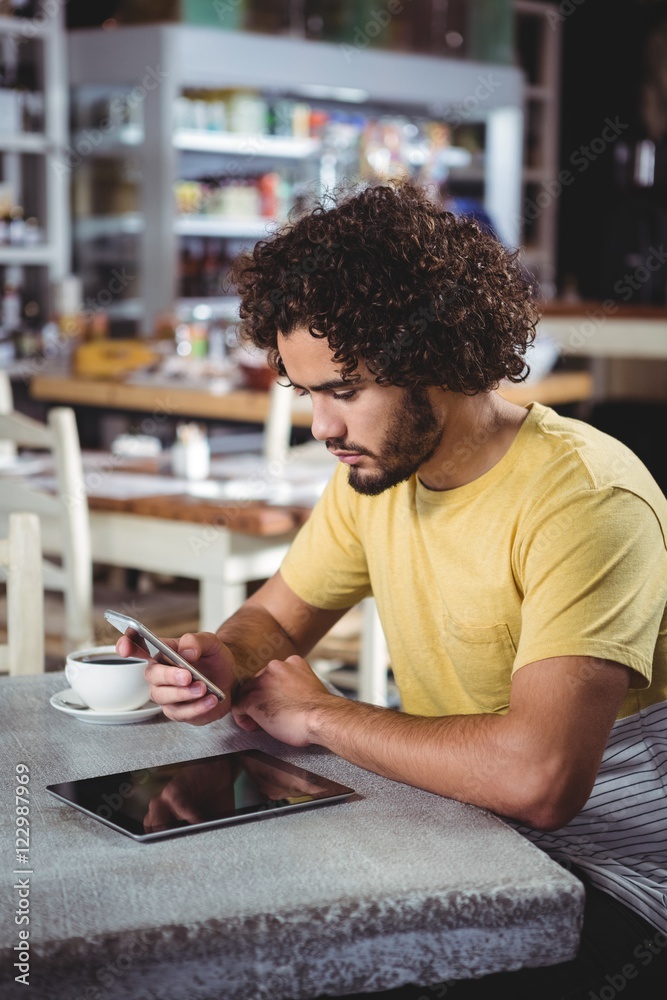 Poster Man using mobile phone while having coffee