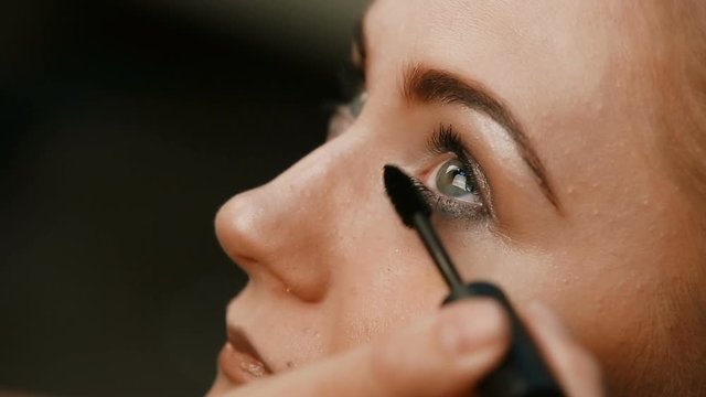 Make-up artist doing make-up eyelashes in a young woman.Makeup. Cosmetic. Base for Perfect Make-up.Applying Make-up.
