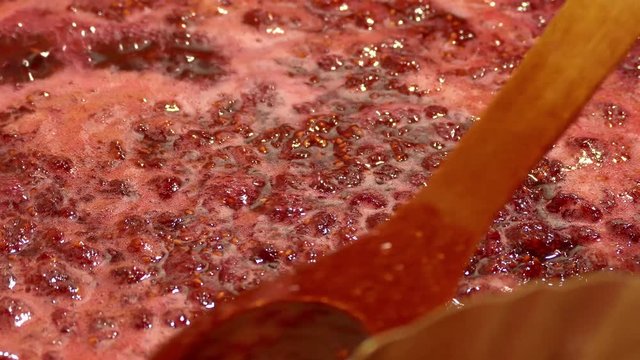 Making raspberry jam. Raw jam boiling in a metal basin.