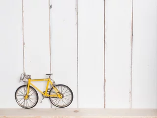 Crédence de cuisine en verre imprimé Vélo yellow bicycle white wood background