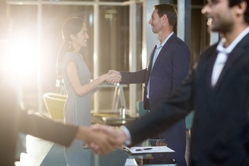 Businessmen shaking hands with colleagues