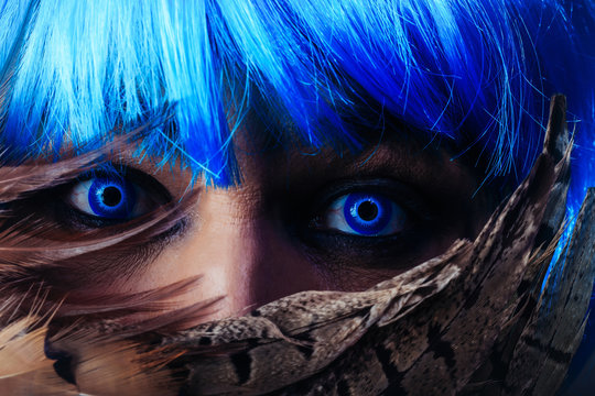 Man in blue wig behing feathers