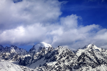 Fototapeta na wymiar Snow mountaims in clouds at sun winter day