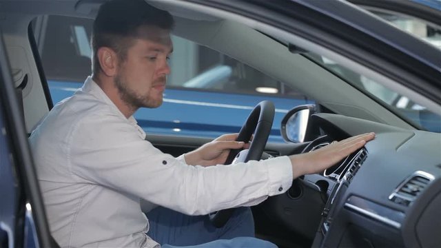 Man examines car interior at the dealership
