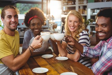 Group of happy friends holding cup of coffee