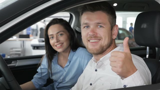 Man shows his thumb up inside the car