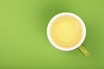 One full big cup of green oolong tea with saucer