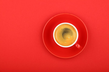 One espresso coffee in cup with saucer on red