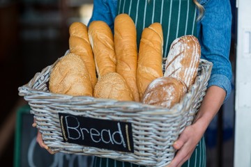 Female staff holding a basket of breads