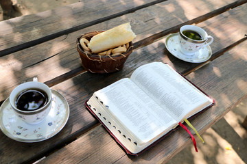 wooden table open book, a number of cups of coffee