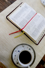  open book and  a design cup of coffee on the wooden table in sunny day in the forest and mobile phone 