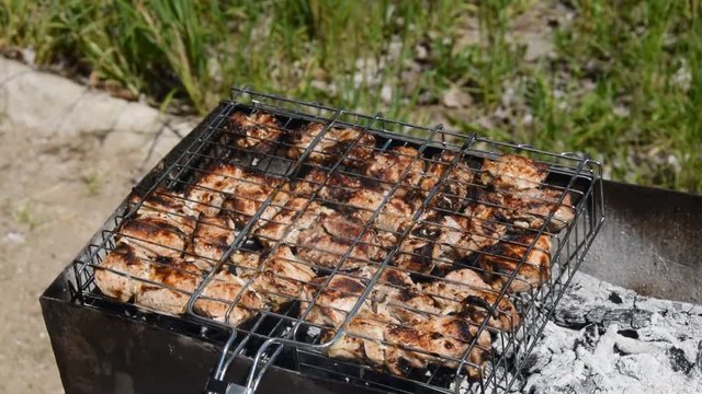 Barbecue meat grilling on charcoal. Tasty grilled meat. Closeup. Cooking meat on  metal grid. Roasted meat with crust. Cooking meat on barbeque grill. Pork meat.