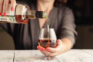 Alcoholism issue. Female take wine glass on dark toned table