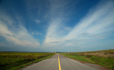 Infinity road in a blue sky with clouds