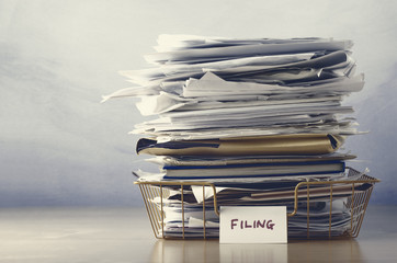 Filing Tray Piled High with Documents in Drab Hues